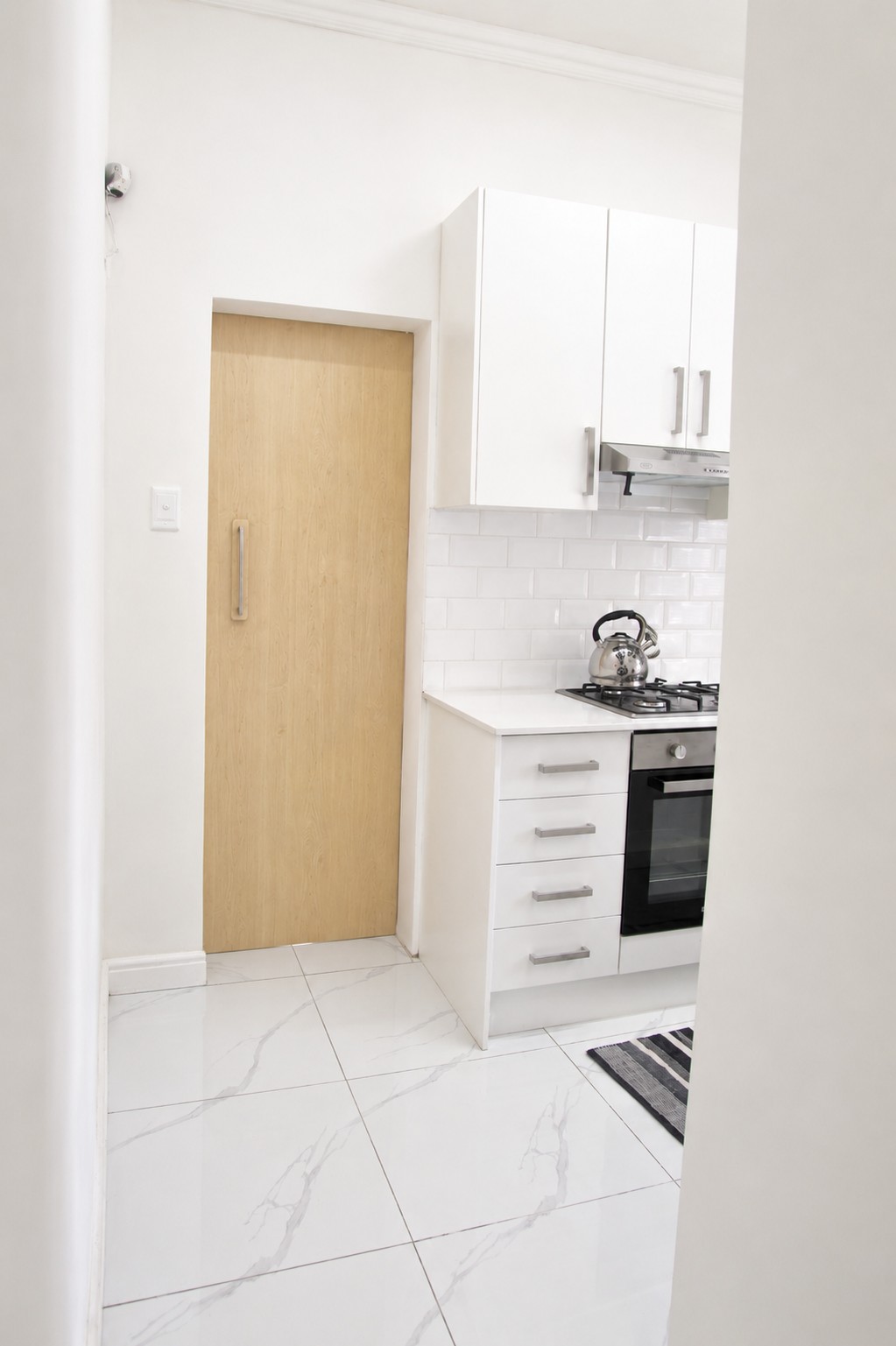 Kitchen entrance with marble-look tiles